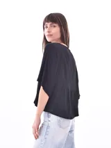 Blusa negra con cuello redondo y abotonadura frontal parcial. Tiene mangas cortas amplias y corte holgado.