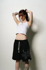 Bermuda negra de algodón con corte oversize y logo trigrama bordado en blanco en la pierna derecha.