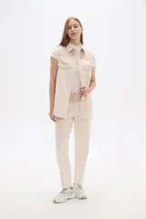 Chaleco color crema con detalles en tejido de espiga en la parte superior y bolsillos.