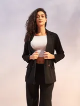 Blazer blanco de lino con doble botonadura y solapas de muesca. Tiene bolsillos delanteros con solapa y corte recto.