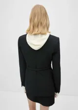 Chaqueta negra con cuello de pico con solapa, diseño recto, cuatro bolsillos de parche en la parte delantera y cinturón.
