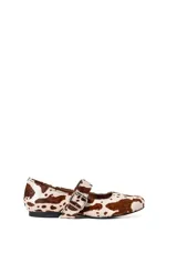 Chatitas de pelo con estampado animal print de vaca, con tira sobre el empeine y hebilla metálica.