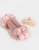 Set de accesorios para el cabello que incluye un rizador sin calor de tela satinada color rosa, dos scrunchies de tela satinada color rosa y un broche de plástico color durazno.