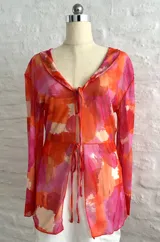 Camisa de manga larga con estampado abstracto en tonos rosados, naranjas y blancos.