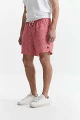 Short de baño estampado con cintura elástica, cordón ajustable, dos bolsillos laterales y uno trasero. Confeccionado en tela ligera de secado rápido y logo bordado.