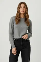 Sweater color crema con cuello redondo, manga larga y diseño de pequeños puntos en relieve.