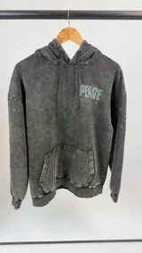 Canguro gris oscuro con efecto lavado, capucha con cordón ajustable y puños elásticos. Estampado en la espalda con la palabra "PEACE" en letras grandes color verde agua y símbolos relacionados con la paz.