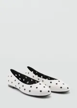 Zapato tipo ballerina color blanco con perforaciones circulares y punta redonda.