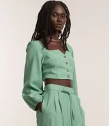Blusa cropped de sastrería color verde agua, con escote cuadrado, mangas largas abullonadas y botones matizados.