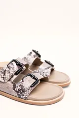 Sandalias marrones de cuero vacuno con doble tira y hebillas metálicas ajustables.