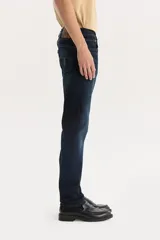 Pantalón de jean azul oscuro, corte slim, tiro bajo y confección stretch.