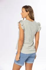 Remera color verde claro con estampado floral y volados en las mangas.