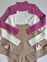 Pack de sweaters de punto acanalado con cuello alto y mangas largas con botones decorativos en los puños.