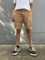 Bermuda de gabardina color marrón claro, corte recto, con bolsillos cargo laterales y bolsillos traseros con solapa.