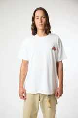 Remera blanca de manga corta con cuello redondo y un pequeño estampado en el pecho izquierdo con texto en rojo y negro.