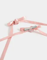 Set de dos hebillas para el pelo, con lazos de satén color rosa claro y detalle de flor en el centro.