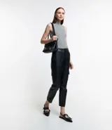 Musculosa negra de punto acanalado con cuello alto y tirantes anchos.
