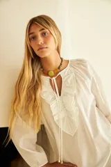 Vestido largo color marrón con tajos laterales, escote con volados y lazos con punteras metálicas.