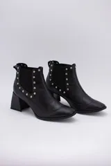 Botas cortas negras de cuero con elásticos laterales, taco cuadrado y apliques de tachas plateadas.