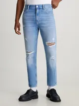Pantalón de jean celeste con roturas, de corte recto y tiro medio.