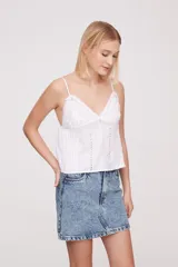 Musculosa blanca de breteles finos con detalles de encaje en el escote y bordado calado en el cuerpo.