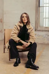 Botas negras de cuero con caña baja, taco cuadrado y detalle de tachas plateadas en la base.