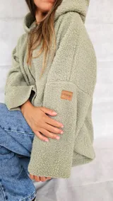 Campera color ocre con capucha y cierre frontal asimétrico.