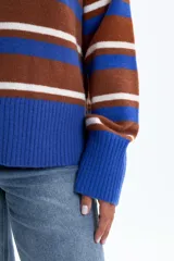 Sweater de tejido de punto con cuello redondo, mangas largas y puños y ruedo acanalados. Presenta un diseño de rayas horizontales anchas en azul eléctrico, marrón óxido y blanco.