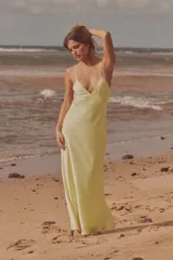 Vestido midi amarillo de satén con escote en V, tirantes finos ajustables y espalda con tiras cruzadas.