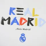 Buzo canguro blanco con capucha y cordones azules. Estampado frontal con el nombre "Real Madrid" en letras de colores y el escudo del club.