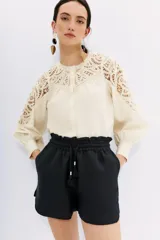 Short negro de calce relajado, con cintura elastizada con cordón de ajuste, tajos y bolsillos laterales.