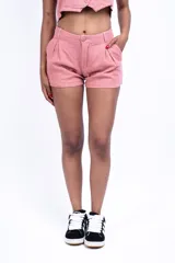Short de vestir rosado con pinzas, bolsillos laterales y cierre frontal con botón.