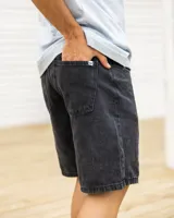 Short de jean negro con corte a la rodilla y ruedo desflecado.