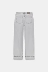 Jeans de tiro alto color negro lavado, con cintura cruzada, cinco bolsillos y pernera recta. El bajo está acabado en vuelta y tiene cierre frontal cruzado con cremallera y botones.