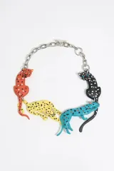 Collar de metal plateado con dijes de panteras de colores: naranja, amarillo, turquesa y negro con lunares blancos.