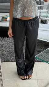 Pantalón negro de lurex con cintura elástica y corte recto.