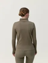 Campera negra con cierre frontal, cuello alto y mangas largas. Confeccionada con tecnología 3D y tejido fit_tech.