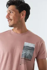 Remera blanca de algodón con cuello redondo y estampado rectangular con imagen de una carretera y texto en el frente.