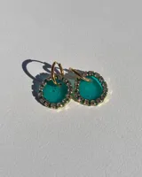Par de aros colgantes con dije circular de resina color turquesa con borde de strass y arito de acero quirúrgico dorado.
