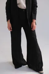 Pantalón de vestir negro de tiro alto, corte palazzo y pierna ancha.
