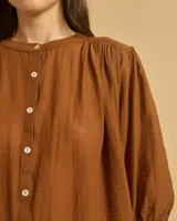 Camisa color crema, de corte holgado, con cuello mao y mangas 3/4 abullonadas.