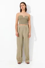 Pantalón de vestir color beige con pinzas, tiro alto, cintura elástica, bolsillos al bies y piernas amplias con raya adelante. Corte relajado.