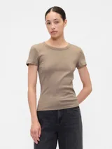 Remera color beige claro, de punto canalé con cuello redondo y mangas cortas. Corte ajustado al cuerpo.