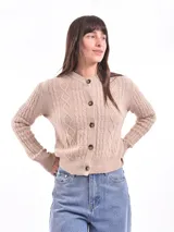Cárdigan tejido color gris claro con diseño trenzado, cuello redondo y cierre frontal con botones marrones.