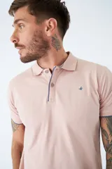 Polo blanco de manga corta con logo estampado y cierre parcial con botones. Corte regular.