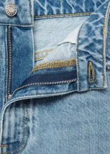 Pantalón de jean celeste claro, corte mom fit, con tiro alto, cinco bolsillos y cierre con cremallera y botón.