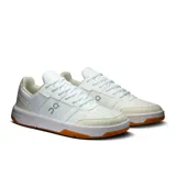 Championes urbanos de cuero sintético blanco, con suela de goma color caramelo y logo de la marca en el lateral.