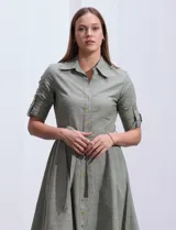 Vestido camisero blanco de algodón con cuello con solapa, delantera abotonada, mangas 3/4 regulables con presilla y botón, y cintura con lazo de ajuste.