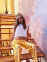 Pantalón dorado de calce relajado, cintura elástica, bolsillos delanteros y traseros, de textura suave y liviana.