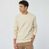Sweater color crema de punto de piqué con cuello redondo y mangas largas.